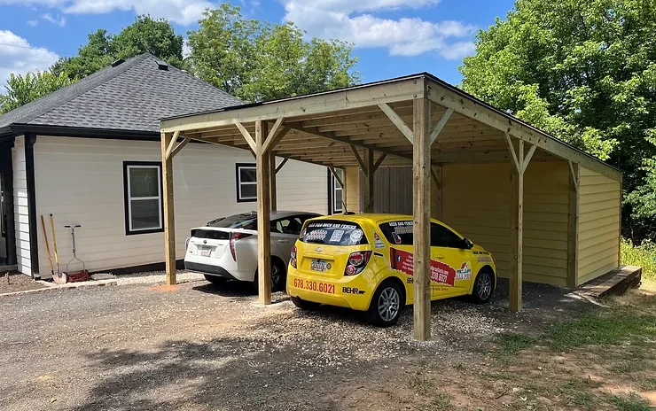 wooden carport with white and yellow cars